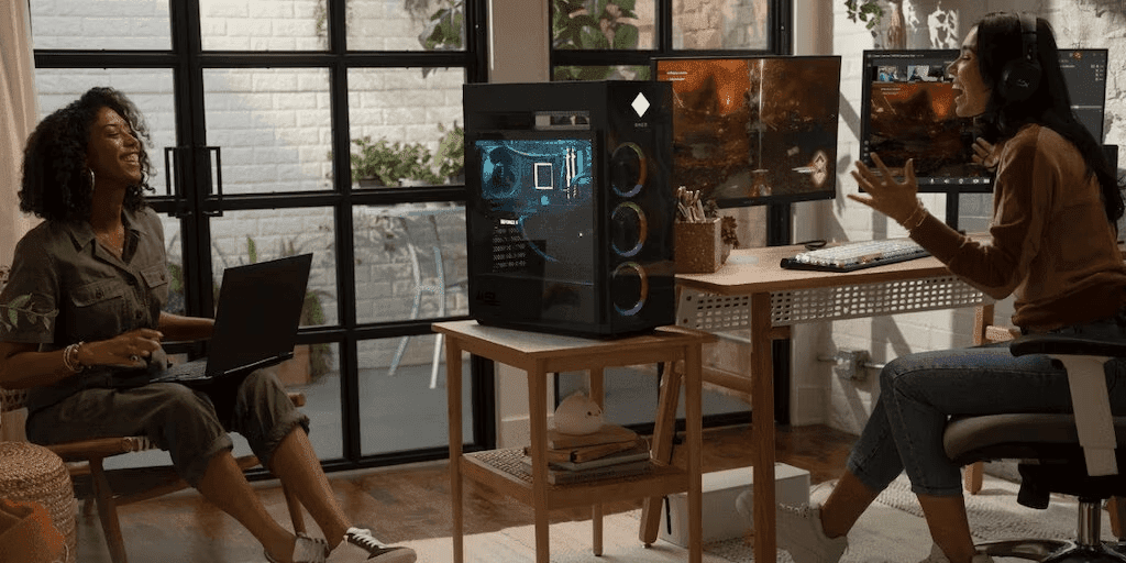 Two young women talking in an office with an HP OMEN 45L